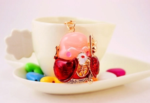 Macro detail of cartoon Longevity God keychain with red enamel robe and gold Shou symbol