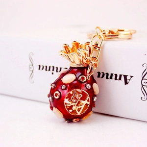 Chinese red enamel fortune bag keychain with golden rhinestones and character Cai