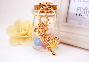 Detailed view of leopard keychain with brown rhinestones hanging on a glass jar