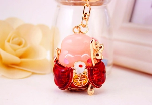 Detail of cute Chinese longevity god keychain with red robe and gold shou character