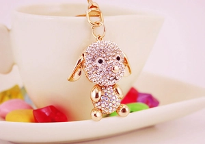 Vue détaillée d'un porte-clés chiot mignon en métal doré orné de strass colorés