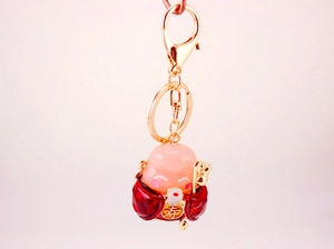 Detailed view of metal God of Longevity keychain with gold finish and crimson robes