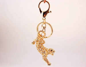 Detailed macro view of gold-plated leopard keychain featuring white crystal rhinestones