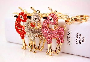 Détails de trois porte-clés chèvre ornés de strass en rouge, argent et rose étincelant