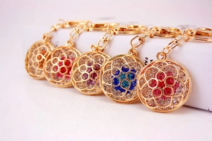 Detailed macro view showing five colors of rhinestone hollow flower keychains on gold alloy