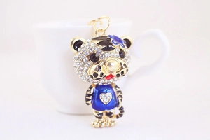 Détail d'un porte-clés tigre mignon avec émail bleu et strass brillants sur base dorée