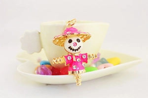 Detailed close-up of a pink enamel scarecrow keychain with sparkling rhinestones