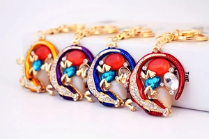 Détail de porte-clés lézard en cristal coloré avec base dorée et strass brillants
