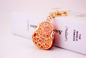 Exquisite golden hollow heart keychain with red inlay resting on a decorative book