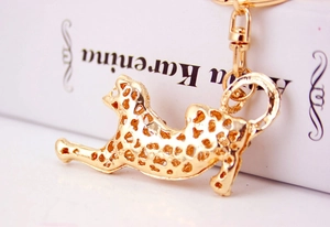 Macro detail of golden leopard keychain featuring hollow mesh craft and jumping pose
