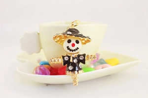 Close-up of a creative gold-plated scarecrow pendant with black enamel and sparkling rhinestones