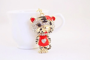 Détail d'un porte-clés tigre doré serti de cristaux blancs et décoré d'émail rouge