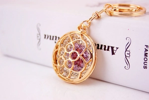 Detail of golden floral镂空keychain with purple rhinestones and lobster clasp closure