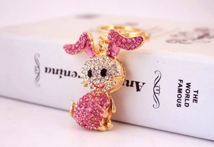Close-up of sparkling pink and white rhinestones on golden rabbit keychain charm
