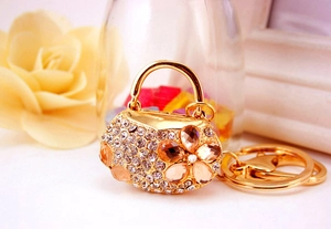 Close-up of golden handbag keychain with sparkling rhinestones and amber crystal flower