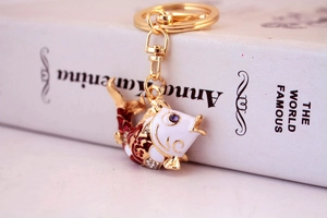 Detailed macro view of white enamel koi fish keychain with red patterns and small rhinestones