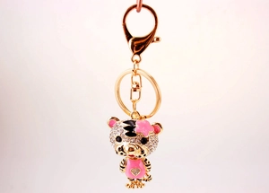 Détail d'un porte-clés tigre du zodiaque avec strass blancs et vêtements à cœur rose