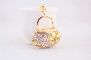 Detail of gold bag pendant with white rhinestones and yellow crystal flower pattern