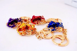 Détails des porte-clés Pi Xiu en émail coloré violet, rouge, jaune et bleu avec cristaux