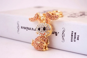 Detailed close-up of rabbit keychain with pink and white rhinestones on a gold metal base