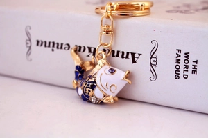 Close-up of enamel koi fish keychain with sparkling rhinestones on a white book