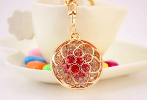 Detailed macro view of a gold flower keychain with pink rhinestones and a metal clasp