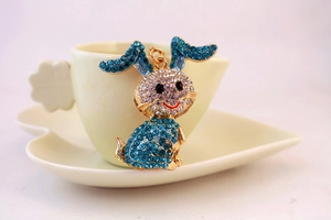 Detailed macro view of a cartoon rabbit keychain with blue and white crystals on a cup