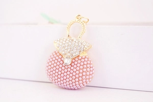 Vue détaillée du pendentif en forme de sac avec perles roses et strass brillants