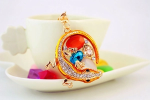 Détail d'un porte-clés lézard en cristal suspendu à une tasse blanche avec des bonbons