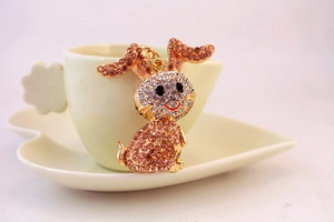 Close-up of pink crystal rhinestone bunny keychain hanging on a white coffee cup