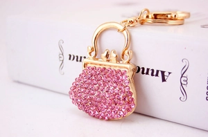 Close-up of golden alloy handbag keychain with shimmering pink rhinestones and a metal ring