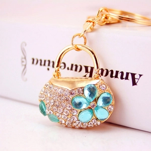 Golden handbag keychain with white rhinestones and blue drop-shaped gemstone flowers