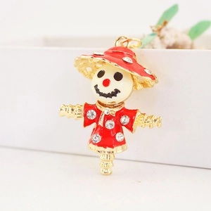 Creative rhinestone scarecrow keychain with red and cream enamel in gold finish