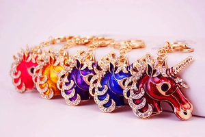 Close-up of five colorful crystal unicorn keychains with gold metal lobster clasps