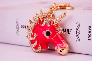Detail of pink crystal unicorn keychain with gold metal spiral horn and white rhinestones