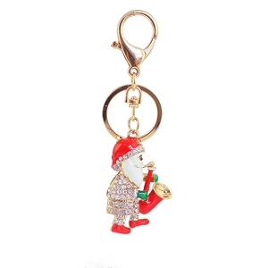 Detailed close-up of golden Santa Claus keychain with saxophone and sparkling rhinestones