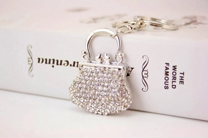 Vista dettagliata del portachiavi a borsa d'argento con strass su un libro bianco