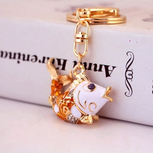 Chinese style koi fish keychain with gold plating and orange enamel on a book background