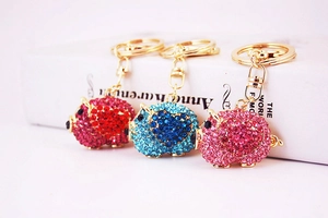 Detailed close-up of cute pig car keychains featuring alloy bases and colorful rhinestones
