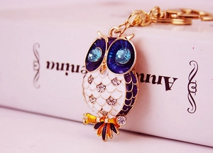 Detail of owl keychain with blue enamel, sparkling crystals, and gold-plated chain