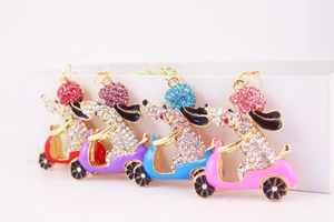 Detalle de cuatro colgantes de perritos con pedrería en rojo, púrpura, azul y rosa