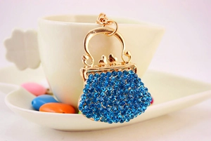 Detail of blue rhinestone handbag keychain with gold plating and heart clasp detail