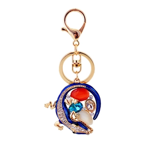 Porte-clés lézard doré avec émail bleu et cristaux colorés sur fond blanc