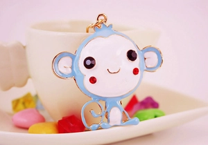 Detailed close-up of sky blue monkey keychain with gold plating and sparkling rhinestones