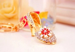 Macro view of crystal rhinestone high heel keychain with floral enamel detail and gold link