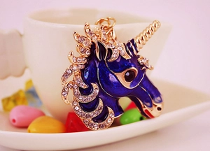 Detailed close-up of a blue enamel unicorn keychain with gold plating and white rhinestones