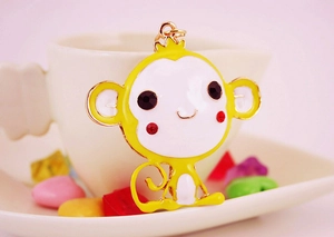 Detail showing cartoon monkey keychain pendant with yellow enamel finish and rhinestone eyes