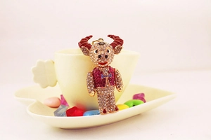 Close-up of sparkling crystal rhinestone ox keychain with red enamel horns and gold alloy base