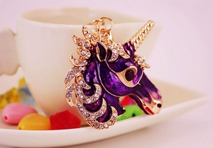 Close-up of purple enamel unicorn keychain with sparkling rhinestones and golden details