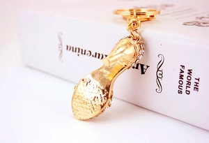 Detailed macro view of a gold high heel keychain with sparkling white rhinestones